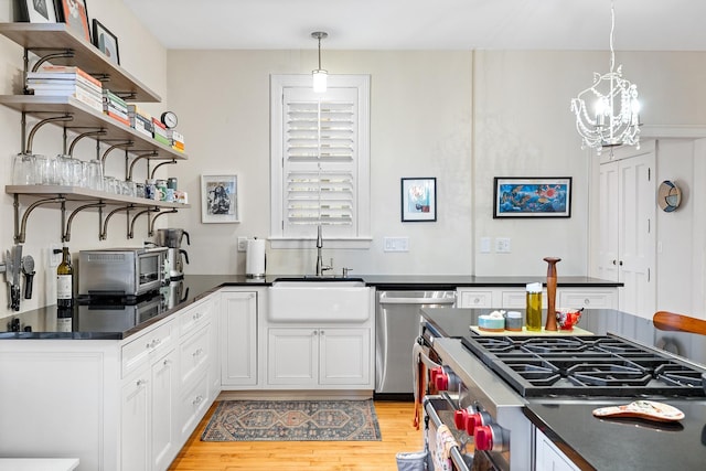 421 Summit Ave Unit 2, Saint Paul, MN 55102 - kitchen with open shelves, a sink, stainless steel appliances, dark countertops, and light wood-type flooring