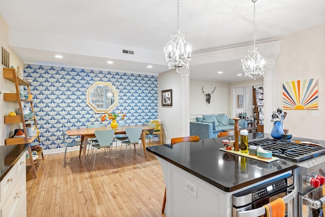 421 Summit Ave Unit 2, Saint Paul, MN 55102 - kitchen featuring dark countertops, a chandelier, white cabinetry, an accent wall, and recessed lighting