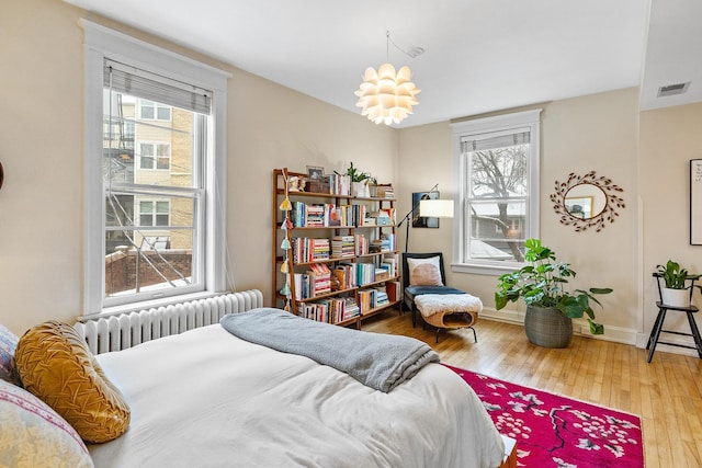 421 Summit Ave Unit 2, Saint Paul, MN 55102 - bedroom with radiator, multiple windows, and hardwood / wood-style floors