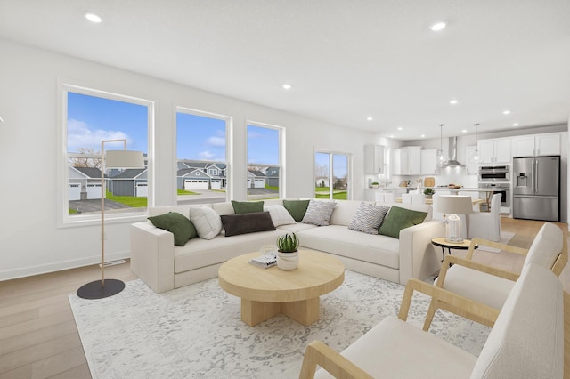 living area with recessed lighting, light wood-style floors, and baseboards