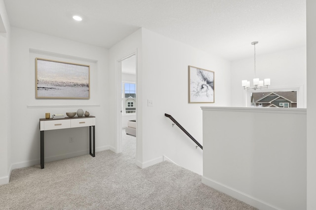 hall featuring an upstairs landing, a chandelier, carpet, baseboards, and recessed lighting