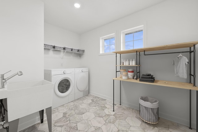 washroom with washing machine and clothes dryer and baseboards