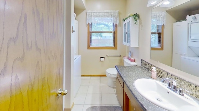 109 Gray Pl W, Marshall, MN 56258 - bathroom featuring stacked washer / dryer, tile patterned floors, vanity, baseboards, and toilet