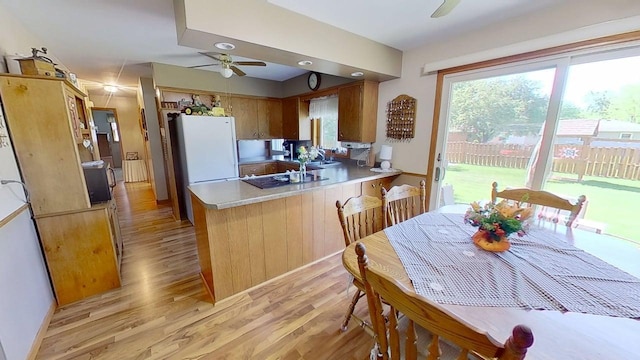 109 Gray Pl W, Marshall, MN 56258 - kitchen with ceiling fan, a peninsula, light wood-type flooring, freestanding refrigerator, and light countertops