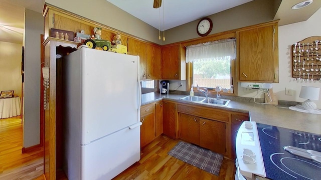 109 Gray Pl W, Marshall, MN 56258 - kitchen with freestanding refrigerator, range, a sink, light wood-style flooring, and brown cabinets