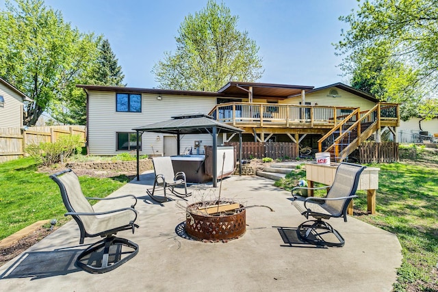 rear view of house featuring a hot tub, an outdoor fire pit, a deck, a gazebo, and a patio