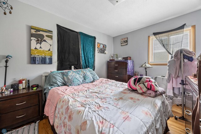 bedroom with wood finished floors and a textured ceiling