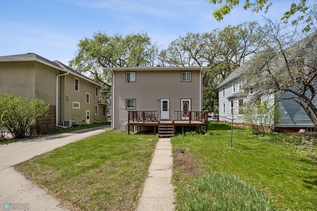 rear view of property featuring a wooden deck and a yard