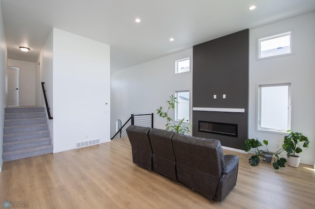 living area featuring light wood finished floors, recessed lighting, and a fireplace