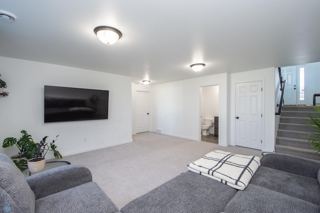 carpeted living area featuring baseboards and stairs