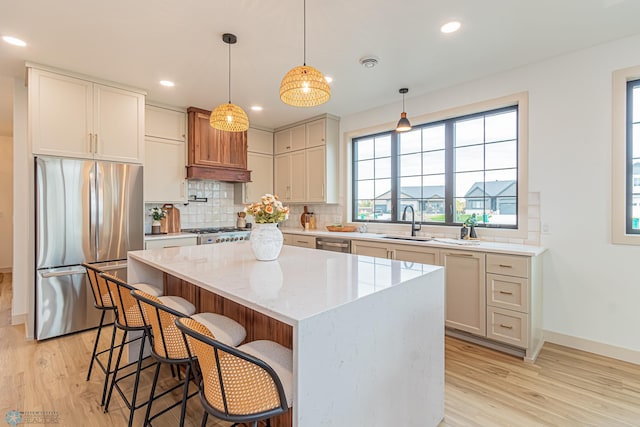 8820 Northern Lights Ave, Fargo, ND 58047 - kitchen featuring stainless steel appliances, light wood finished floors, a sink, decorative backsplash, and recessed lighting