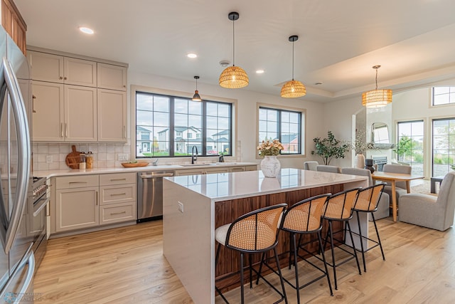 8820 Northern Lights Ave, Fargo, ND 58047 - kitchen featuring stainless steel appliances, a sink, light wood finished floors, a kitchen island, and recessed lighting