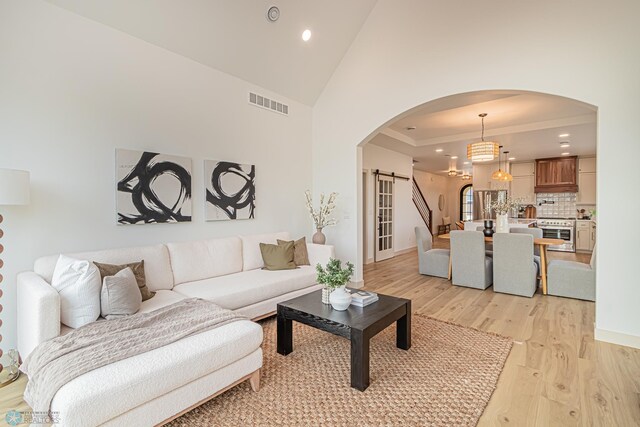 8820 Northern Lights Ave, Fargo, ND 58047 - living area with a barn door, arched walkways, light wood finished floors, recessed lighting, and crown molding
