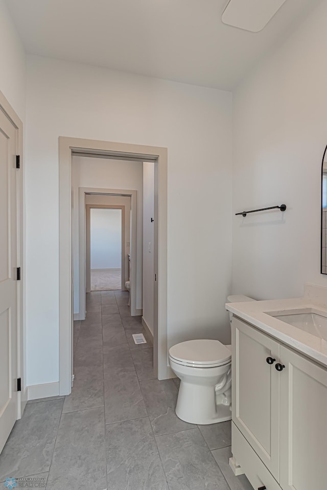 8820 Northern Lights Ave, Fargo, ND 58047 - bathroom with toilet, vanity, and baseboards