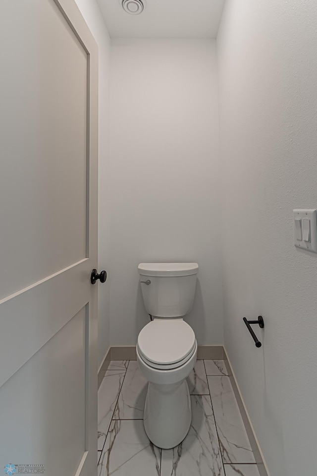 8820 Northern Lights Ave, Fargo, ND 58047 - bathroom with marble look tiles, baseboards, and toilet