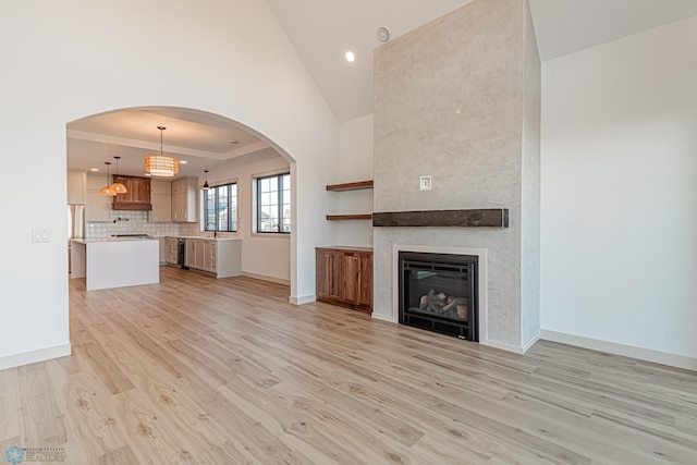 8820 Northern Lights Ave, Fargo, ND 58047 - unfurnished living room featuring light wood-type flooring, baseboards, a fireplace, vaulted ceiling, and recessed lighting