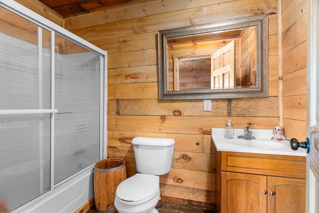 2132 295th Ave, Luck, WI 54853 - full bathroom with wooden walls, toilet, vanity, and combined bath / shower with glass door
