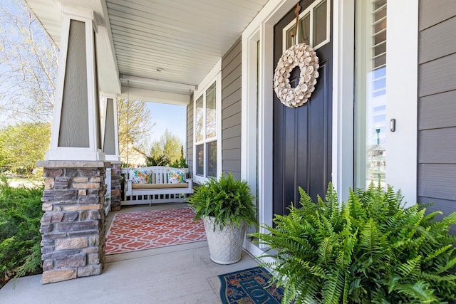 property entrance featuring covered porch and board and batten siding