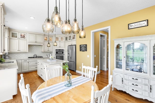 dining area with light wood-style flooring, recessed lighting, and baseboards