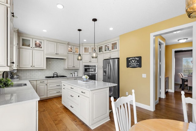 kitchen with stainless steel appliances, a sink, light wood-style flooring, backsplash, and recessed lighting