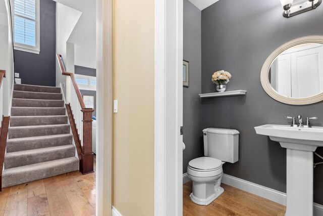 bathroom with wood finished floors, toilet, and baseboards