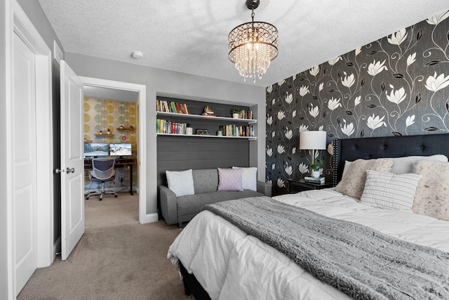 carpeted bedroom with a chandelier, a textured ceiling, a desk, and baseboards