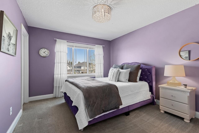 bedroom with carpet floors, baseboards, a textured ceiling, and a chandelier