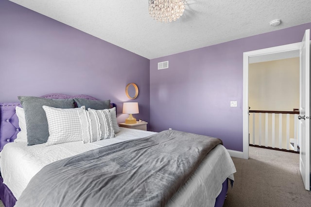 bedroom with carpet flooring, baseboards, a chandelier, and a textured ceiling