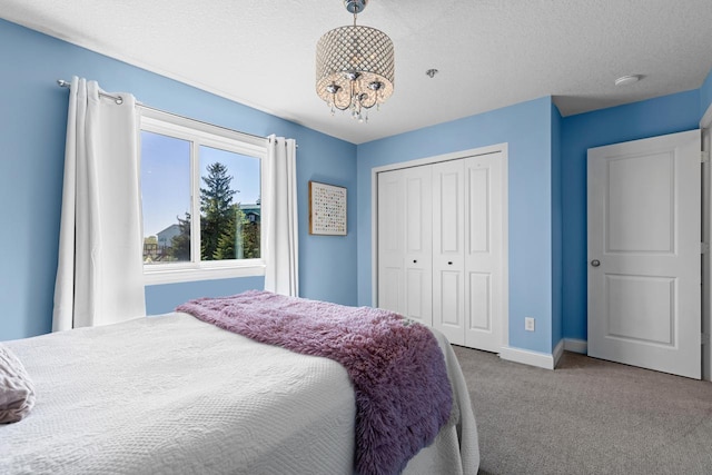 bedroom with carpet floors, baseboards, a closet, and a textured ceiling