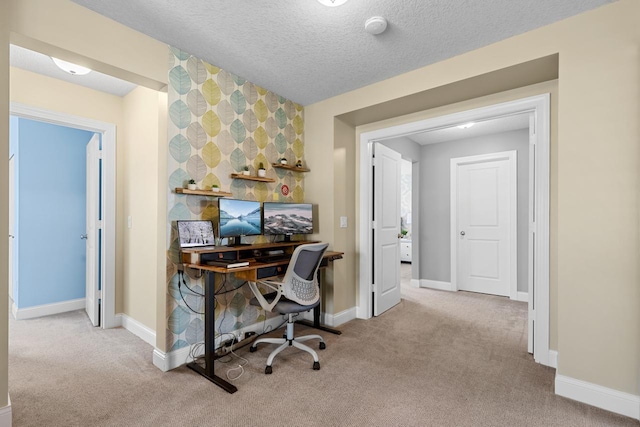 carpeted home office featuring baseboards and a textured ceiling