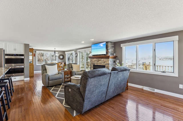 1683 Hansack Ave NE, Saint Michael, MN 55376 - living area with dark wood finished floors, a textured ceiling, baseboards, a fireplace, and recessed lighting