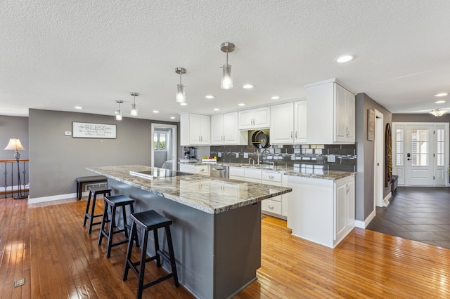 1683 Hansack Ave NE, Saint Michael, MN 55376 - kitchen with dishwasher, light wood-style floors, baseboards, white cabinets, and tasteful backsplash