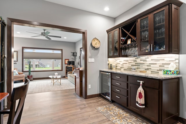 2006 13th Ave NE, Austin, MN 55912 - indoor dry bar featuring wine cooler, backsplash, light wood-type flooring, a ceiling fan, and baseboards