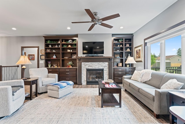 2006 13th Ave NE, Austin, MN 55912 - living area with a ceiling fan, wood finished floors, a stone fireplace, and recessed lighting