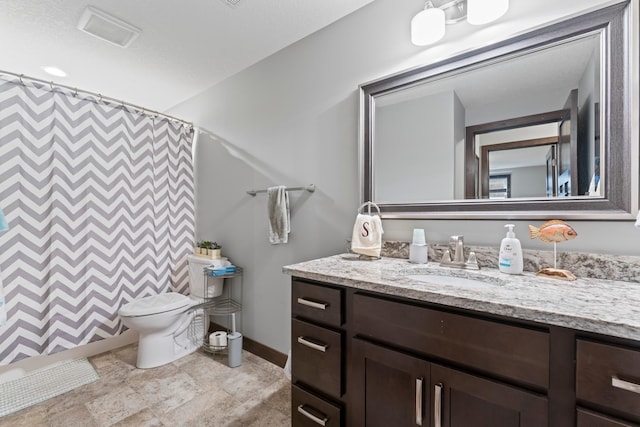 2006 13th Ave NE, Austin, MN 55912 - bathroom featuring vanity, toilet, baseboards, curtained shower, and stone finish flooring