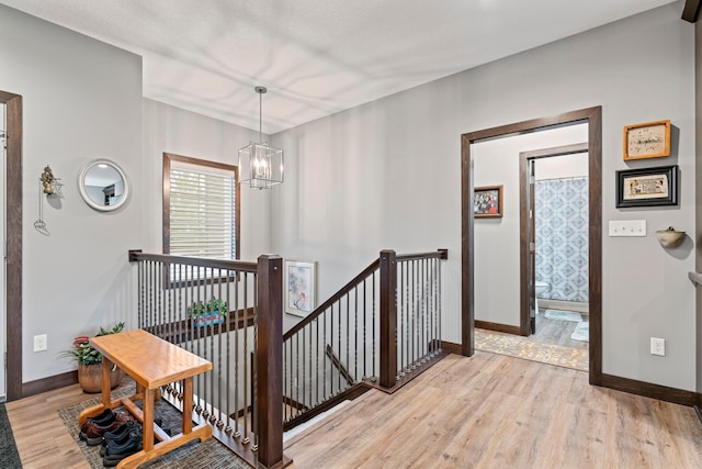 2006 13th Ave NE, Austin, MN 55912 - stairway with a chandelier, baseboards, and wood finished floors