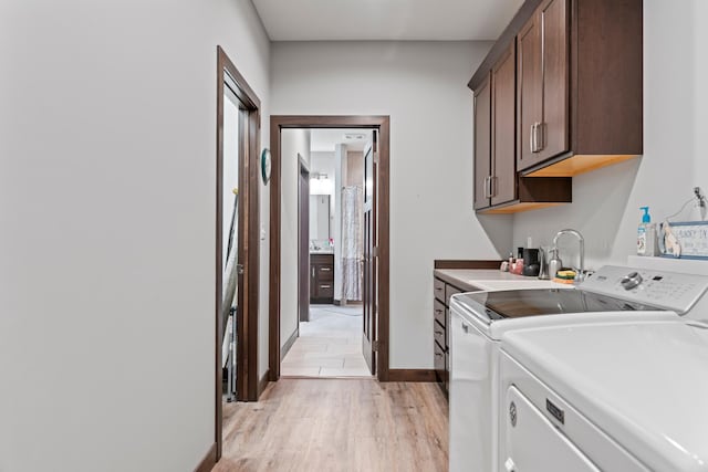 2006 13th Ave NE, Austin, MN 55912 - washroom featuring cabinet space, washing machine and dryer, light wood finished floors, and baseboards