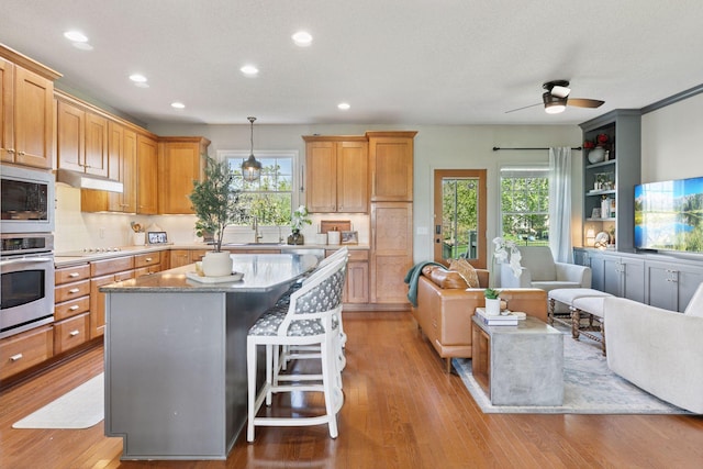 343 Primrose Path, Bayport, MN 55003 - kitchen with stainless steel appliances, a ceiling fan, recessed lighting, backsplash, and a center island
