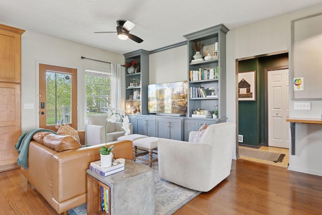 343 Primrose Path, Bayport, MN 55003 - living area with a ceiling fan, wood finished floors, built in features, and a textured ceiling