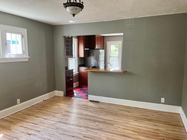 2748 41st Ave S, Minneapolis, MN 55406 - kitchen with freestanding refrigerator, light wood-type flooring, a textured ceiling, baseboards, and dark countertops