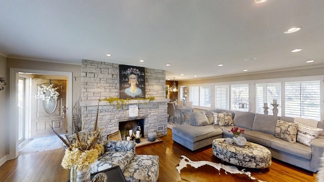 living room featuring crown molding, wood finished floors, a fireplace, and recessed lighting