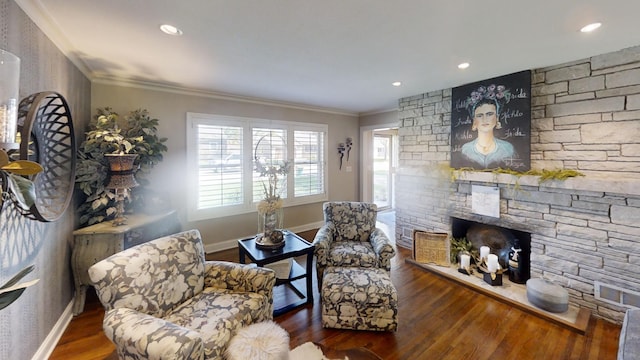 living area featuring a fireplace, baseboards, wood finished floors, and ornamental molding
