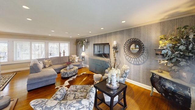 living area featuring wallpapered walls, baseboards, ornamental molding, wood finished floors, and recessed lighting