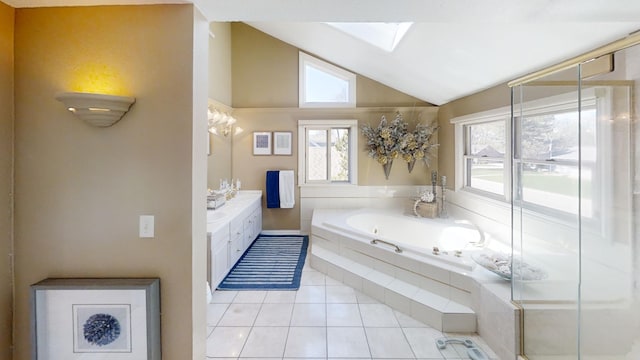 bathroom with lofted ceiling, tile patterned floors, a bath, a skylight, and vanity