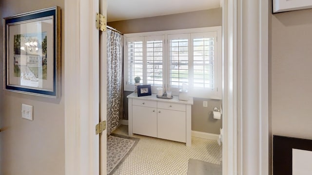 full bath featuring baseboards and a shower with shower curtain