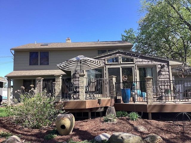 back of property featuring a deck and a shingled roof