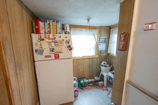 4448 43rd Ave S, Minneapolis, MN 55406 - kitchen with freestanding refrigerator, a textured ceiling, tile patterned floors, and wooden walls