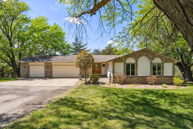 ranch-style house with a garage, brick siding, driveway, and a front lawn