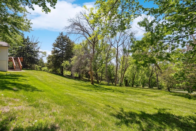 view of green lawn with stairway and a deck