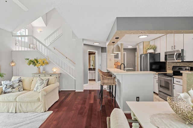 living area featuring stairway, wood finished floors, and baseboards